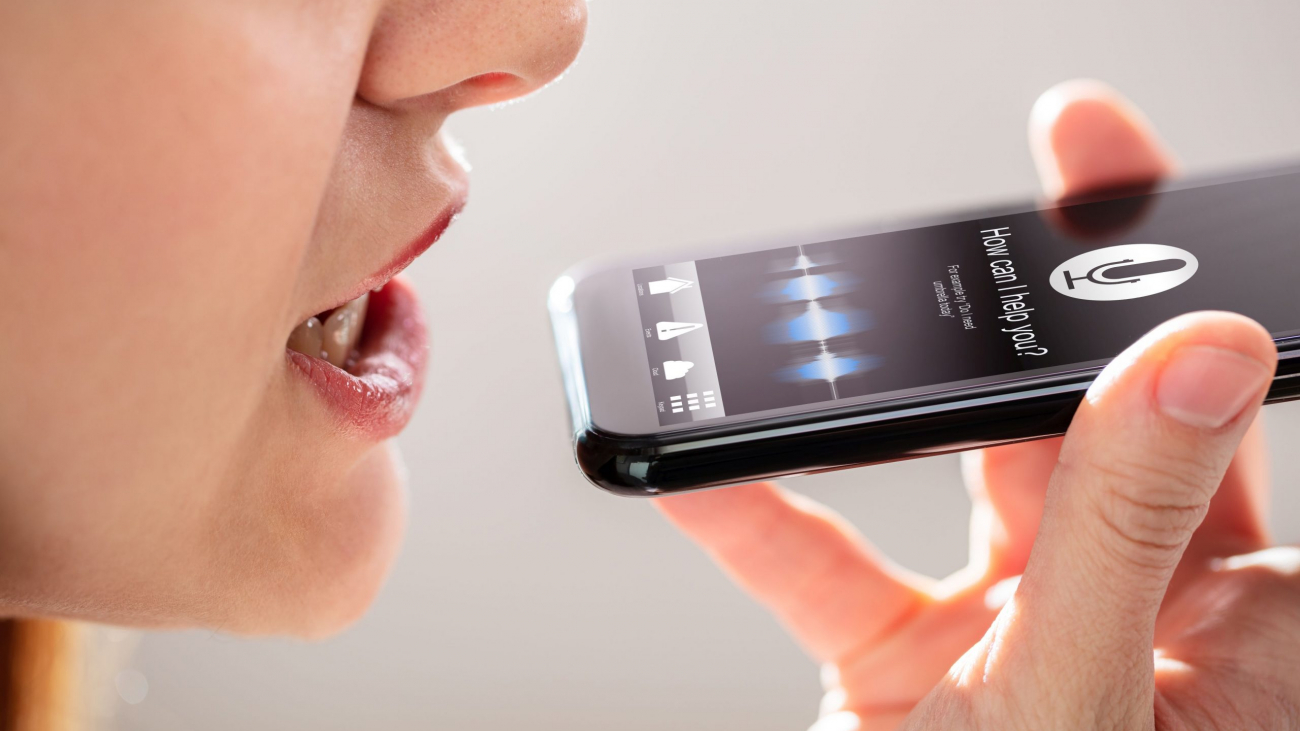 Close-up Of A Young Woman Using Voice Recognition Function On Mobile Phone